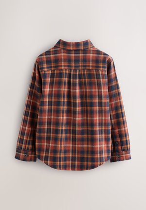 Flanelová košile s dlouhým rukávem a károvaným vzorem v námořnické modři, oranžové a krémové barvě. Zádová část je mírně nařasená, má klasický límec a manžety na knoflíky.