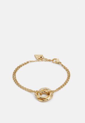 Gouden kettingarmband met verwoven cirkelvormige schakels, waarvan er één versierd is met heldere edelstenen, met een kleine driehoekige hanger en een kreeftsluiting.