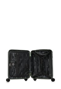 Otevřený zelený tvrdý kufr s černým vnitřním podšíváním, zipovými přihrádkami a nastavovacími popruhy, stojící na čtyřech kolech.