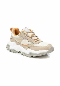 Zapatillas deportivas beige con materiales de malla y ante, que cuentan con una suela gruesa blanca, acentos naranjas y detalles grises. Diseño con cordones.