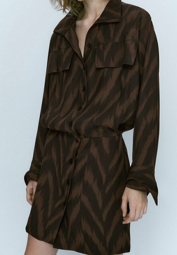 Robe-chemise à motifs marron avec col, manches longues, boutonnage sur le devant et deux poches poitrine. Fabriquée dans un tissu léger à texture lisse.