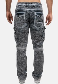 Jeans cargo grigi con un aspetto sbiadito e distressed. Presentano due tasche posteriori, una tasca cargo laterale e cuciture in contrasto.
