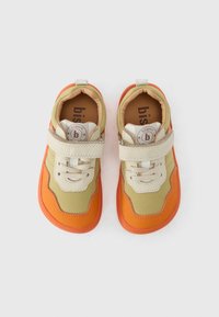 Παιδικά αθλητικά παπούτσια με μπεζ, πορτοκαλί και πράσινο σχέδιο. Διαθέτουν Velcro, κορδόνια και στρογγυλό λογότυπο στη γλώσσα. Λαστιχένια σόλα.