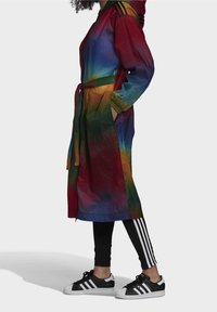 Lehký deštník s barevným blokováním v živých gradientních odstínech (červená, modrá, zelená), s kapucí, páskem v pase a bočními kapsami.