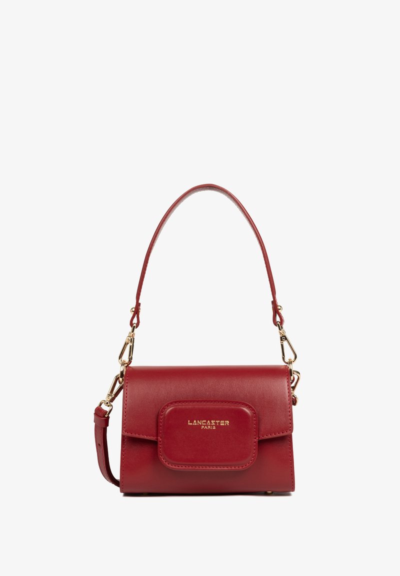 Sac à main en cuir rouge avec un design structuré, des accessoires en or, une poche avant à rabat et une bandoulière amovible pour des options de transport polyvalentes.