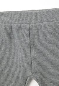 Grijze gebreide leggings met een ribbeltextuur, voorzien van een hoge tailleband en uitsparingen bij de enkels voor een aansluitend ontwerp.