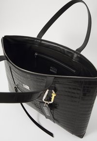 Schwarze Ledertasche mit Krokodilprägung, ausgestattet mit einem Reißverschluss, Innenfächern und einem Metallakzent. Verstellbare Trageriemen sind enthalten.