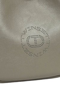 Borsa in pelle beige texturizzata caratterizzata da un design con logo perforato. Forma arrotondata con una finitura morbida e manico superiore per un facile trasporto.