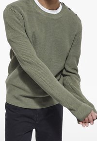 Maglione verde oliva lavorato a maglia con scollo rotondo e texture a costine, con dettagli di bottoni sulla spalla e maniche lunghe.