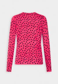 Maglione rosa lavorato a maglia con un motivo a pois blu navy, scollatura rotonda e maniche lunghe. Orlo a coste in vita e sui polsini.