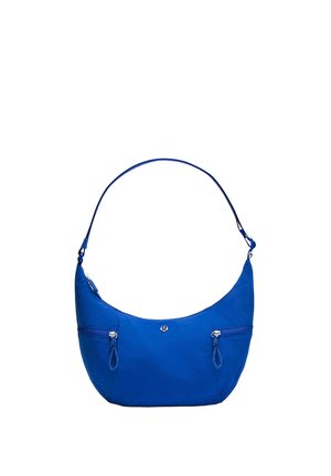 Sac à bandoulière bleu en forme de croissant avec deux poches avant zippées et une sangle réglable, avec un petit logo rond au centre.