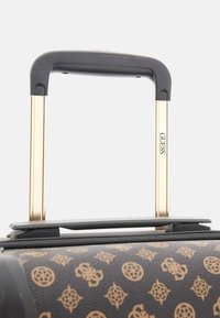 Black patterned suitcase with golden telescopic handle and gray accents. Features a textured surface with a logo. Zipper closing at the top.