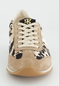 Baskets à motifs beige et noir avec une tige en daim, des accents blancs, des lacets plats et un logo doré sur une languette noire. Semelle en caoutchouc.