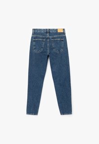 Jeans de denim azul con un diseño ajustado, piernas ligeramente entalladas y dos bolsillos traseros. Incluye una etiqueta de cuero marrón en la cintura.