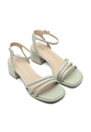 Sandales à talons blocs synthétiques verts avec un design à trois straps, orteils ouverts et bride de cheville ajustable. Fini lisse avec semelles intérieures beiges.