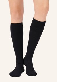 Calze nere fino al ginocchio in materiale a costine con un motivo testurizzato e colore uniforme, dotate di un bordo superiore aderente per un indosso sicuro.