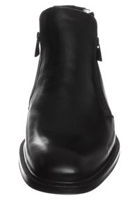 Bottine en cuir noir avec une surface lisse, une fermeture éclair latérale, un bout arrondi et une semelle texturée avec des détails minimalistes.