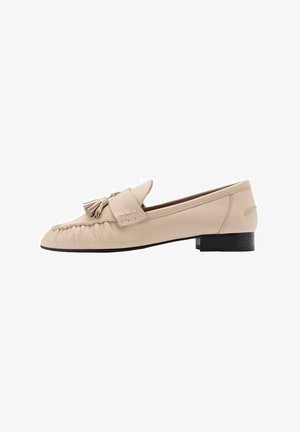 Beige læder loafers med en rund tå, der har en kvastdekoration og syede detaljer. Flad hæl og glat tekstur.