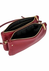 Sac à bandoulière en cuir bordeaux avec deux compartiments zippés, quincaillerie dorée et surface texturée. Doublure en tissu noir à l'intérieur.