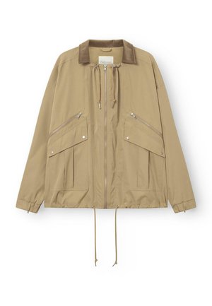 Veste beige zippée avec col en velours côtelé, cordons de serrage au cou et à l'ourlet, poignets élastiques, et plusieurs poches zippées et à boutons-pression à l'avant.