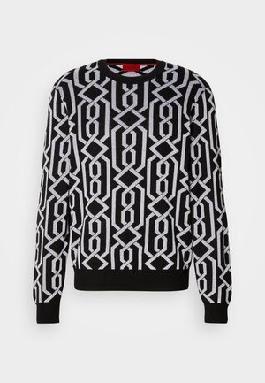 Maglione nero con un motivo geometrico bianco, scollatura tonda, maniche lunghe e polsini e orlo a costine. Realizzato in materiale a maglia.