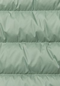 Lichtgroene, gevoerde stof met een gladde textuur, voorzien van horizontale naden en een subtiel ruitpatroon.