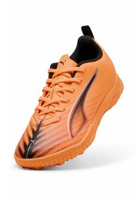 Zapatilla deportiva naranja con un patrón texturizado, detalles en negro y un diseño ligero. Cuenta con un cierre de cordones y un cuello acolchado.