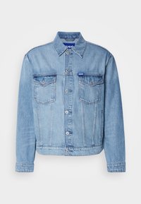 Light blue denim jacket with a button-up front, two chest pockets, and a fold-down collar. Features a branded tag on the collar.
