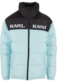 Lysblå pufferjakke med en sort lynlås krave, kontrasterende paneler og broderet tekst "KARL KANI" på den øverste front.