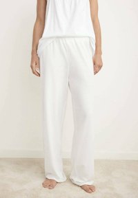 Pantalones blancos fluidos con cintura elástica y piernas rectas y anchas, hechos de una tela suave y liviana.