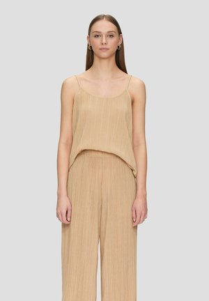 Beige geplooide mouwloze top met een ontspannen pasvorm, delicate bandjes en een zachte textuur. Gepaard met bijpassende losse broek.