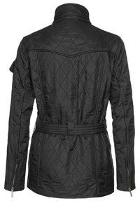 Casaco acolchoado preto com gola alta, cintura cingida e bolsos laterais com fecho. Apresenta padrões em diamante e textura lisa.