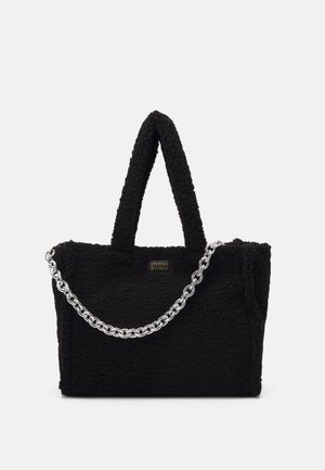 Czarna, puszysta torba na ramię z teksturowanej tkaniny, z krótkimi uchwytami i długim srebrnym łańcuszkiem. Z przodu znajduje się złota tablica z logo.