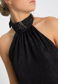 Haut halter noir avec un design plissé et des accents de fil métallique. Tissu lisse, col haut et détail de lien au cou.