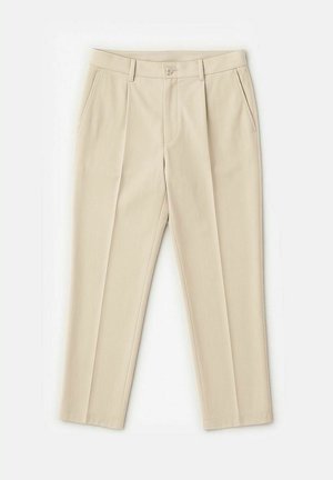 Beige byxor med veck, tillverkade av slät tyg. Har en krokupphängning och dragkedja, samt sidofickor. Rakt ben-design.