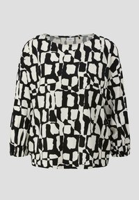 Blouse à motifs noir et blanc, avec une coupe ample, un col rond et des manches froncées, réalisée dans un tissu texturé et lisse.