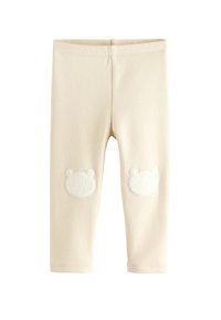 Leggings color crema realizzati in morbido tessuto, con toppe a forma di orso bianco sulle ginocchia. Texture liscia, design aderente e vita elastica.