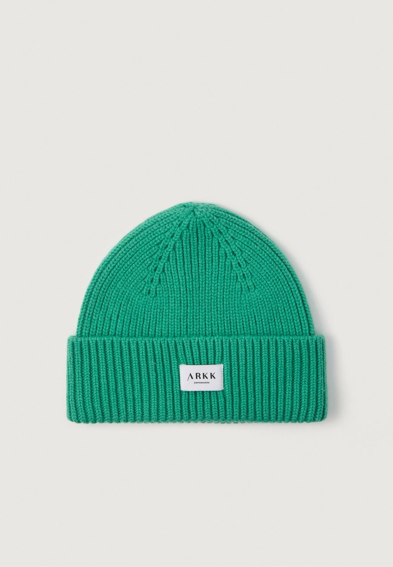 Berretto in maglia verde realizzato in materiale morbido, con risvolto piegato e una piccola etichetta bianca con il marchio "ARKK" sul davanti.