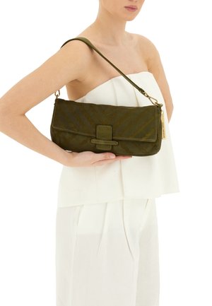 Borsa a tracolla verde oliva con un motivo a zigzag testurizzato. Presenta una tracolla piatta e un dettaglio della chiusura prominente sul davanti.