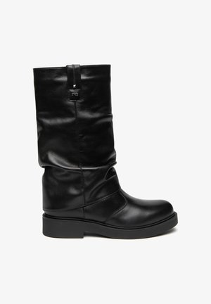 Bota de cuero negra hasta media pantorrilla con puntera redondeada, tacón bajo y grueso, caña caída y pequeña lengüeta cosida cerca de la parte superior.