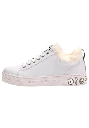 Witte lage sneaker met bontvoering, decoratieve stenen op de hiel, witte veters en "GUESS" branding op de zool.