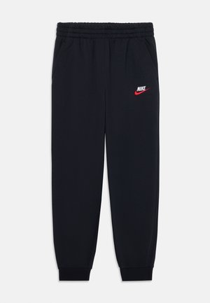 Czarne spodnie dresowe Nike z elastycznym pasem, bocznymi kieszeniami, ściągaczami przy kostkach oraz białym i czerwonym logo Nike na lewym udzie.