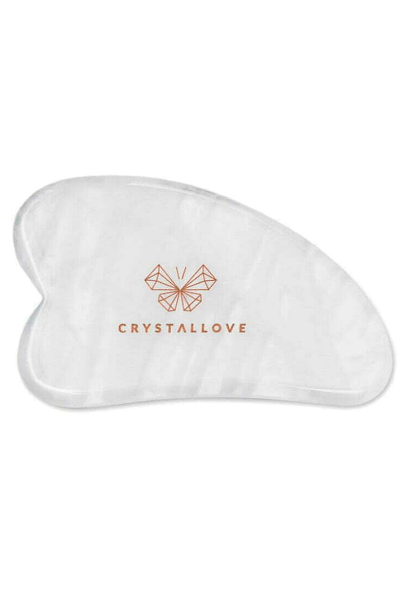 Przezroczyste, białe narzędzie gua sha o wygiętym kształcie, z złotym logo "CRYSTALLOVE" oraz geometrycznym wzorem motyla.