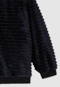 Felpa nera a costine realizzata in materiale effetto pelliccia testurizzata. Il design presenta strisce orizzontali ben evidenti e un polsino in costina nera uniforme.