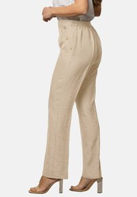 Pantalones de lino beige con pierna recta, cinturilla elástica y dos botones decorativos en el lateral. Textura suave y diseño ligero.