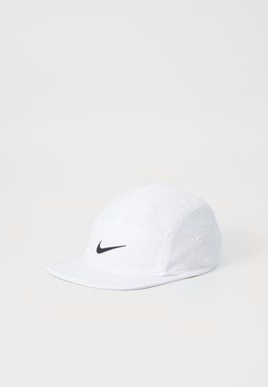 White baseball cap made of fabric with a black Nike swoosh emblem on the front. Features a curved brim and adjustable strap at the back.