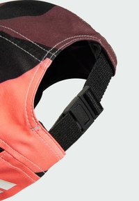 Cap baseball hat featuring a pink and black camo pattern, made of soft fabric with stitched seams and an adjustable black strap at the back.