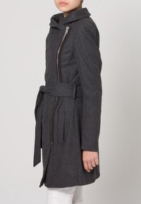 Grauer Wollmantel mit Kapuze, seitlichem Reißverschluss und Gürtel. Verfügt über zwei vordere Taschen mit Klappen und eine gerade Silhouette. Weiche Textur.