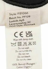 Etichetta con istruzioni per la cura, con testo in bianco e nero, che elenca le indicazioni di lavaggio e la composizione del materiale (100% cotone organico).