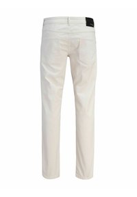 Pantaloni bianchi in cotone con taglio dritto, dotati di due tasche posteriori e di una toppa con logo nero sulla cintura. Tessuto liscio.